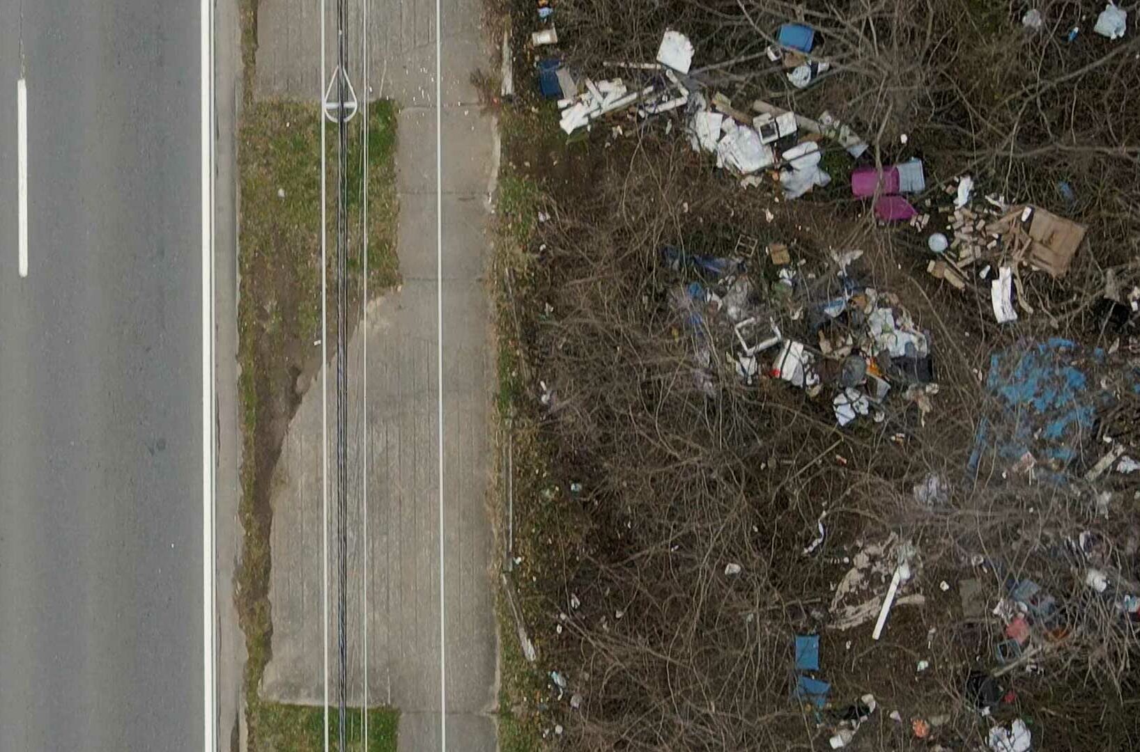 Large amount of litter next to a road.
