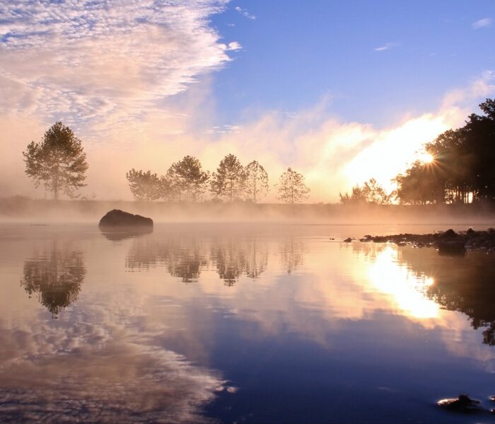 Sunrise mist on a blue lake