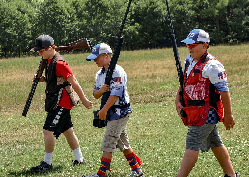 Three athletes walking in a field