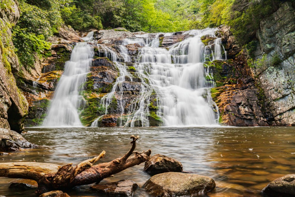 Waterfall rushing down moss-covered rocks into a stream below. Photo by Chad Woodhouse. 