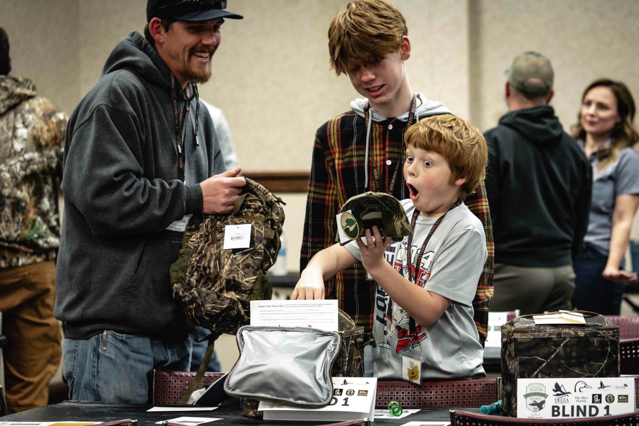 Excited Youth at Friday Banquet Opens Prizes from Delta Waterfowl.